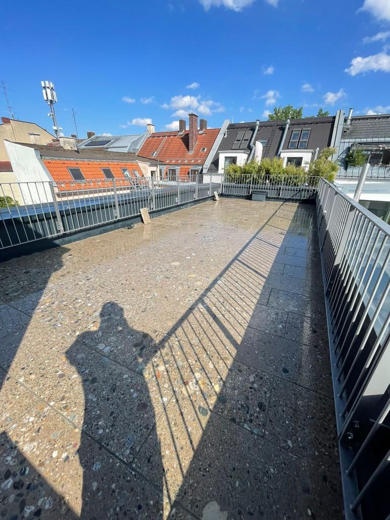 Dachterrasse München: fertig verlegter Naturstein, Spezialaufbau, Estrichpumpe und Schlauchführung bis in den 5. Stock, Montage und Statikerabstimmung (1/6)